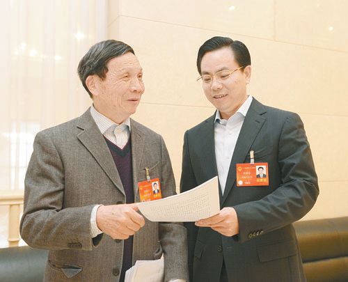 黃伯云代表（左）與劉國忠代表商討完善《關(guān)于建立戰(zhàn)略性新興產(chǎn)業(yè)國家創(chuàng)新平臺》的建議。 本報記者 張目 攝